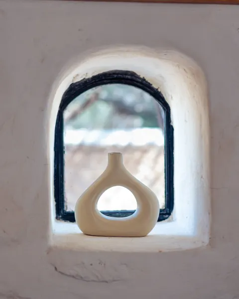 La Pluméria, vase blanc dans une niche de fenêtre